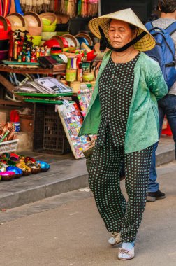 Hoi An / Vietnam - Mart 06: 2019: Yerel bir sokak pazarında yürüyen yaşlı bir Vietnamlı kadın.