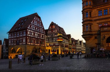 Rothenburg ob der Tauber / Almanya - 26 Temmuz 2019: En sevilen buluşma noktası ve Rotherburg ob der Tauber 'deki Pazar Meydanı veya Pazar yeri etrafında alacakaranlıkta.