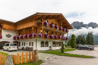 Ellmau / Austria - August 02 2019: traditional housing with the Wilder Kaiser in the back. clipart