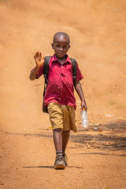Kibale Ulusal Parkı / Uganda - 27 Şubat 2020: Kırsal alanda tek başına yürüyen bir çocuk.