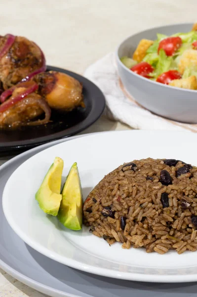 Salad chicken avocado and rice with black beans. This is a typical caribbean food.