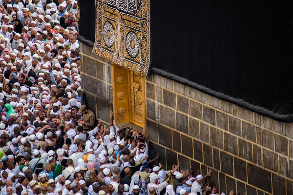 Dav lidí se snaží dotknout dveří Svaté Kaaby v Masjid Al Haram. Část Tawafa. Čtou Duu, když se dotýkají dveří.. — Stock fotografie