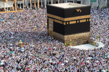 The Holy Kaaba. Crowd of people walking around Kaaba. Tawaf part during Umrah or Hajj clipart