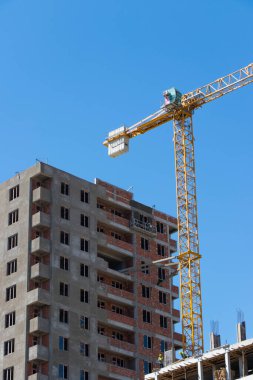 Yapı vinci ve mavi gökyüzüne karşı bina.