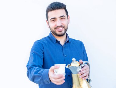 Elinde kahve fincanı tutan Arap bir adam.