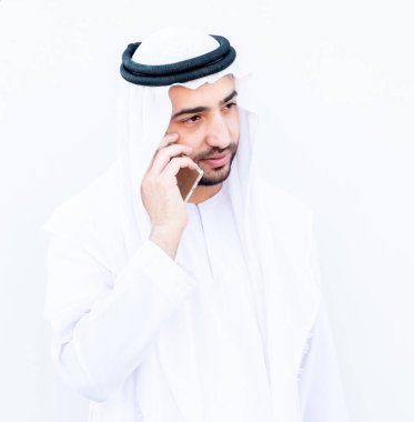 Arap Müslüman adam internetteki insanlarla iletişim kurmak için akıllı telefonunu kullanıyor.