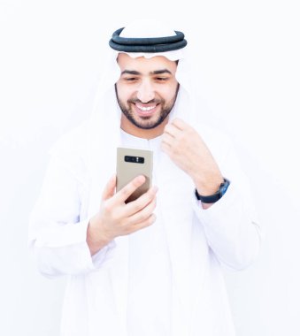 Arap Müslüman adam internetteki insanlarla iletişim kurmak için akıllı telefonunu kullanıyor.