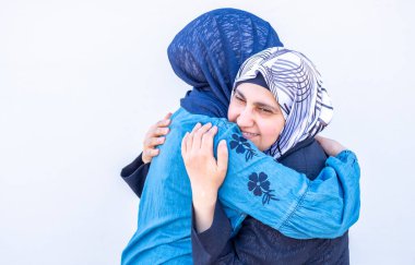 Arap Müslüman kızı annesine sarılıyor.