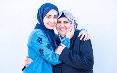 Arap Müslüman kızı annesine sarılıyor.