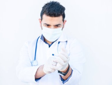 Kendini enfeksiyondan korumak için eldiven takan Arap doktor.