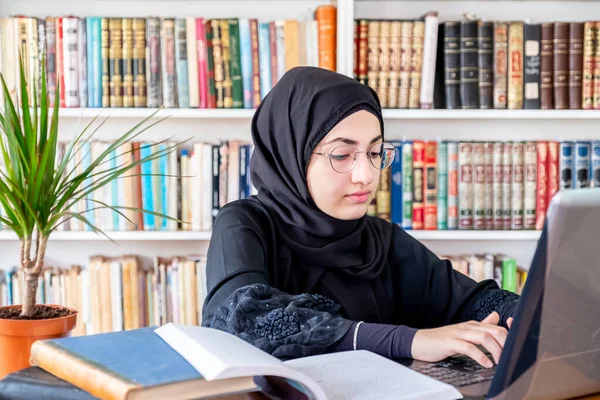 Arabic muslim woman using laptop for online meetings and studying