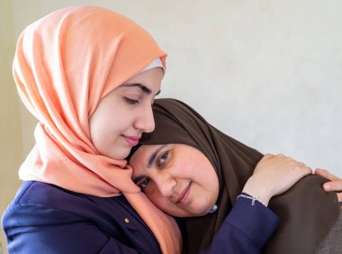 Arap Müslüman anne ve kızı birbirlerine sarılıyorlar.