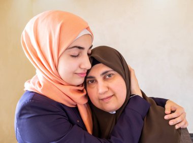 Arap Müslüman anne ve kızı birbirlerine sarılıyorlar.