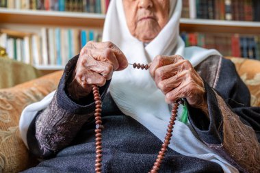 Arap Müslüman adam tespih çekerek Tanrı 'ya dua ediyor.
