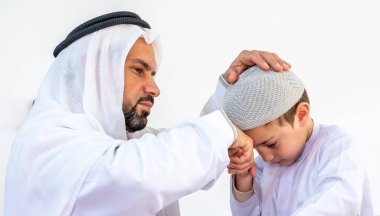 Arap Müslüman çocuk babasının elini öpüyor.