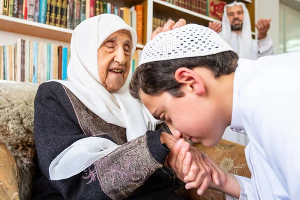 アラビア語イスラム教徒の息子キス彼の祖母の手 — ストック写真