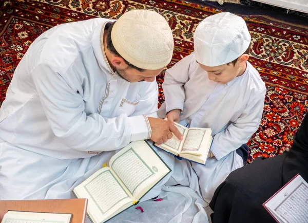 Happy arabic family reading and learning quraan during ramadan