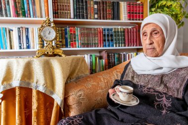 Arap msulim yaşlı kadın kahve içiyor.