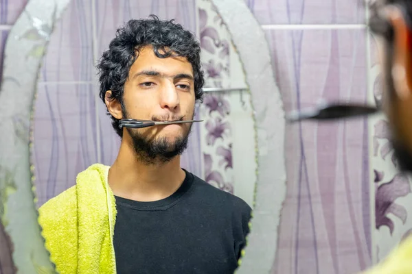 一个阿拉伯穆斯林男人自己剪头发 — 图库照片