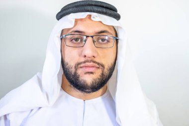 Arap Müslüman adam gözlüğünü tutuyor.