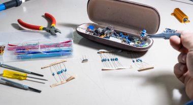 Elleriyle elektronik parçaları tutan adam.