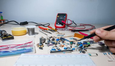 Elleriyle elektronik parçaları tutan adam.