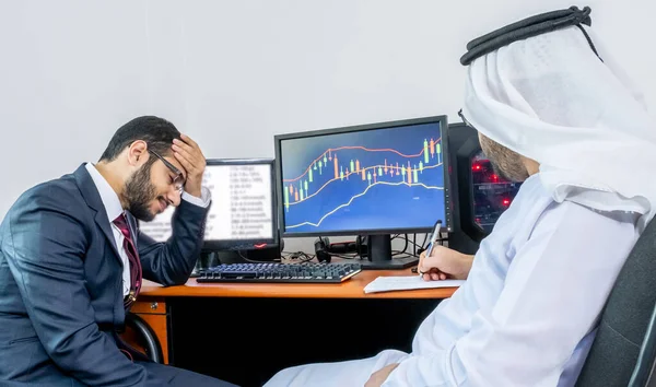 Pazar trendi ve hisse senetlerini tartışan iki Arap Müslüman erkek
