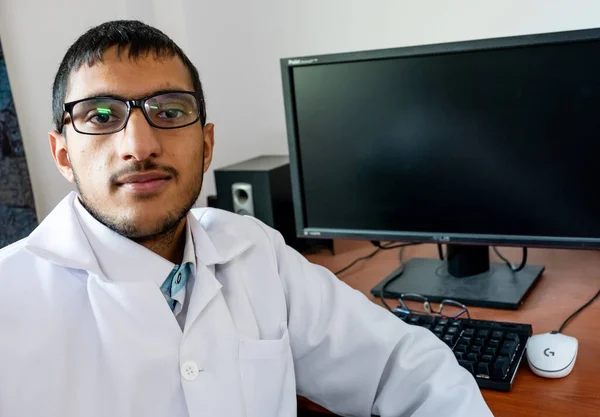 Arabic muslim doctor siiting on his computer