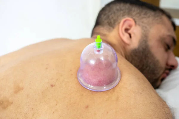 Derisini düzeltmek için sırtını sıvazlayan Arap adam.