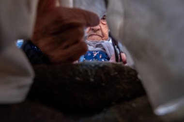 Müslüman kadın makasla bez kesiyor.