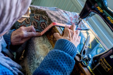 Arap Müslüman kadın, bant ile dikiş dikiyor ve boyunu ölçüyor.