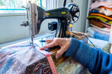 Arap Müslüman kadın, bant ile dikiş dikiyor ve boyunu ölçüyor.