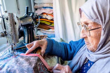 Arap Müslüman kadın, bant ile dikiş dikiyor ve boyunu ölçüyor.