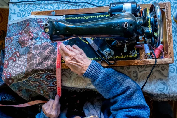 アラビア語のイスラム教徒の女性の縫製と彼女のテープで長さを測定 — ストック写真