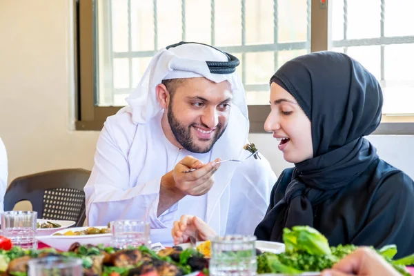 Arap Müslüman koca karısına yemek yediriyor.