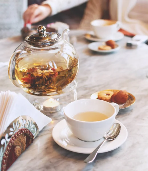 Théière en verre transparent avec thé vert sur une table dans un café, mise au point sélective — Photo