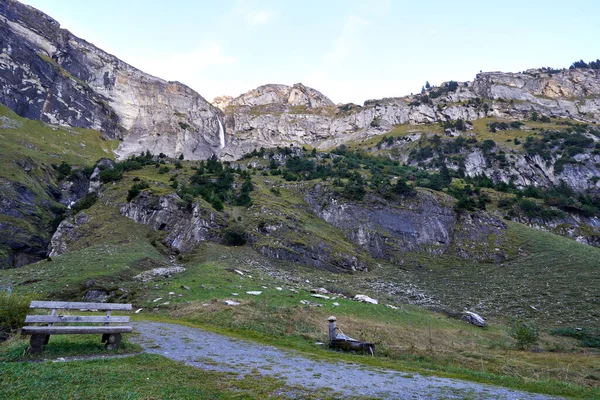 Suiza Alpes Graubuenden Paisaje de montaña con cascada y banco —  Fotos de Stock