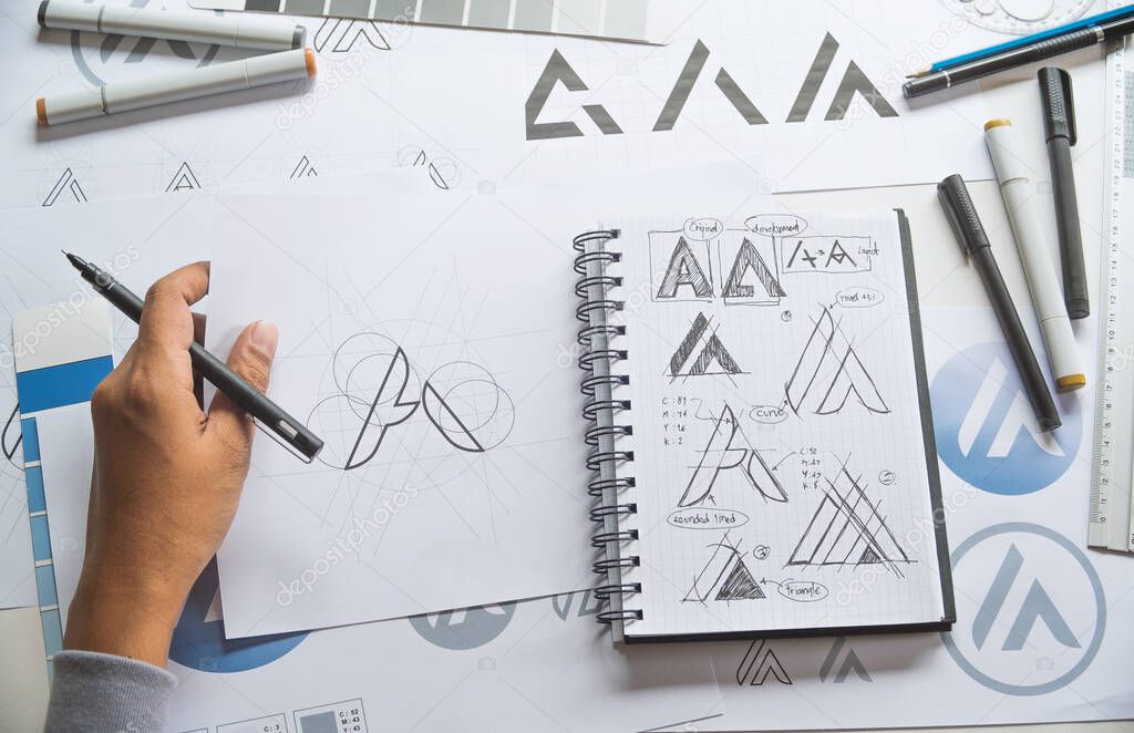 Graphic designer development process drawing sketch design creative Ideas draft Logo product trademark label brand artwork. Graphic designer studio Concept.