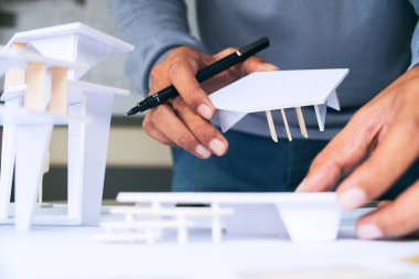 Mimari tasarım tasarımı çizim planları çiziyor ve mimar stüdyosunda mimari yapı modelleri yapıyor.