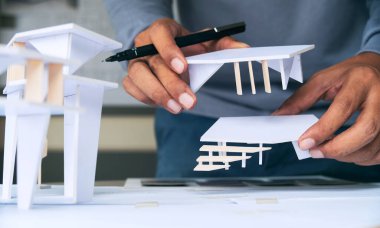 Mimari tasarım tasarımı çizim planları çiziyor ve mimar stüdyosunda mimari yapı modelleri yapıyor.