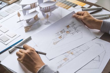 Mimari tasarım tasarımı çizim planları çiziyor ve mimar stüdyosunda mimari yapı modelleri yapıyor.