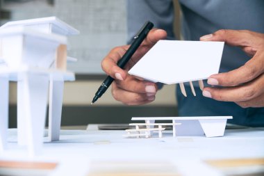 Mimari tasarım tasarımı çizim planları çiziyor ve mimar stüdyosunda mimari yapı modelleri yapıyor.