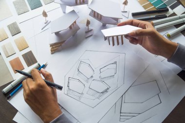 Mimari tasarım tasarımı çizim planları çiziyor ve mimar stüdyosunda mimari yapı modelleri yapıyor.