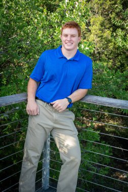 Handsome, red- headed young man posing for his High School graduation photos. Very attractive and athletic looking young boy.