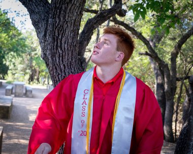 Handsome, red- headed young man posing for his High School graduation photos. Very attractive and athletic looking young boy.