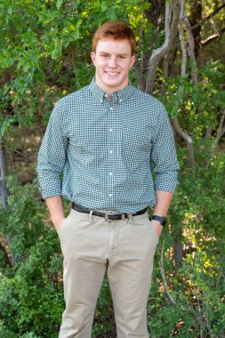 Handsome, red- headed young man posing for his High School graduation photos. Very attractive and athletic looking young boy.