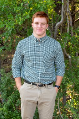 Handsome, red- headed young man posing for his High School graduation photos. Very attractive and athletic looking young boy.
