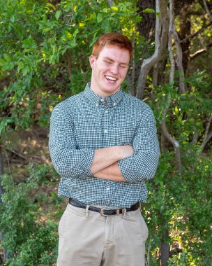 Handsome, red- headed young man posing for his High School graduation photos. Very attractive and athletic looking young boy.