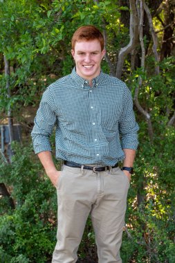 Handsome, red- headed young man posing for his High School graduation photos. Very attractive and athletic looking young boy.