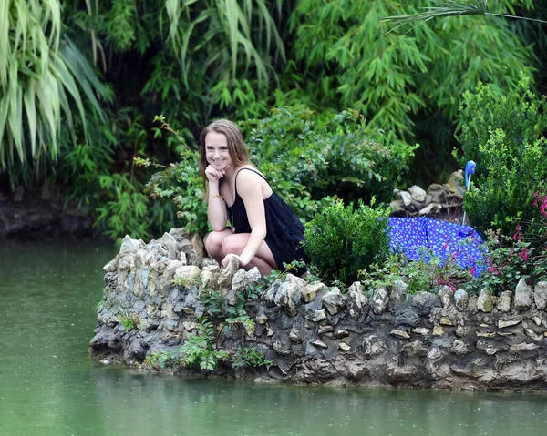 Young Female High School Senior posing for Senior photos in a beautiful park setting